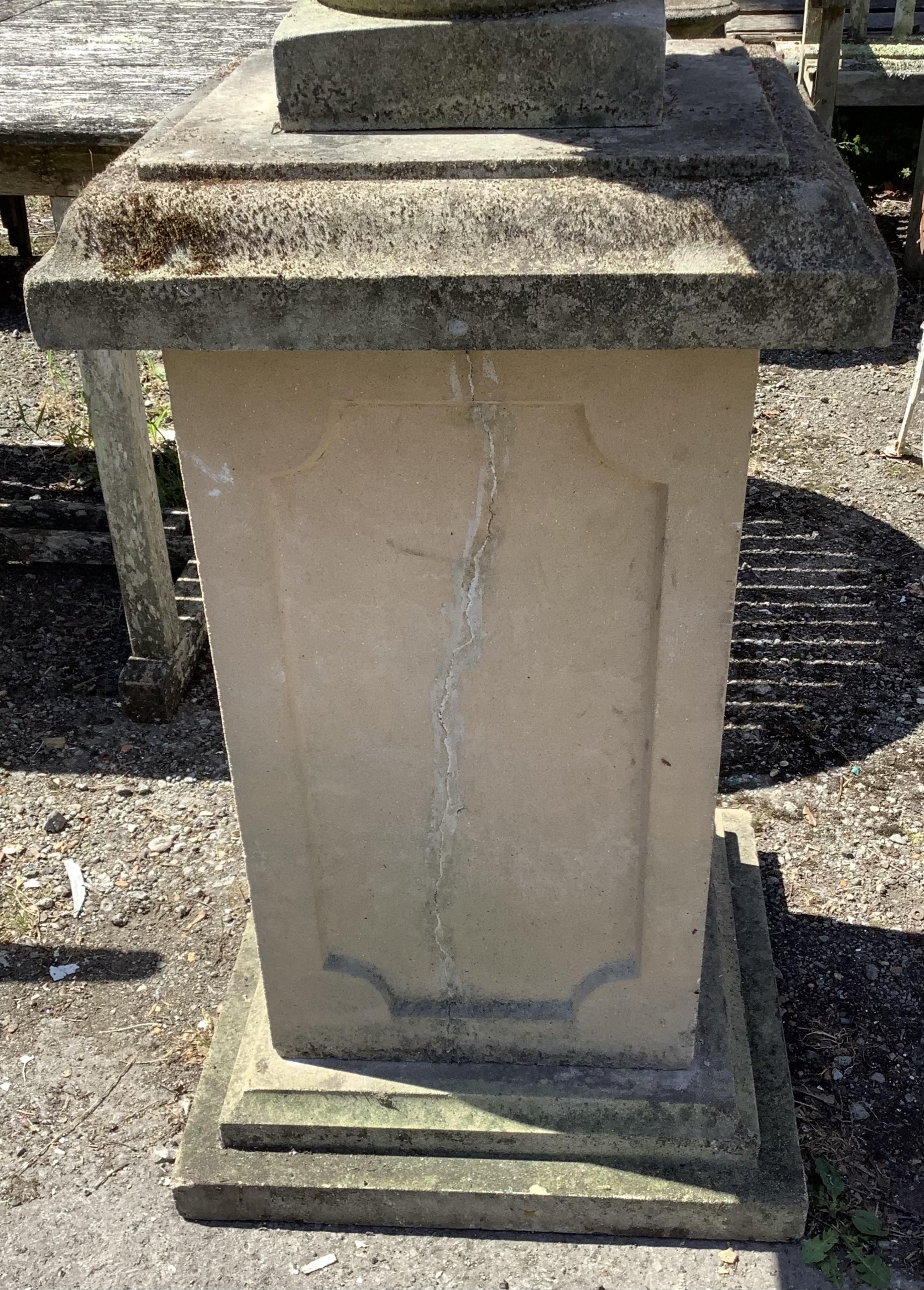 A reconstituted stone Adam style lidded garden urn on a square pedestal base, height 160cm